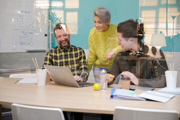 Obraz premium Three colleagues working at computer in conference room