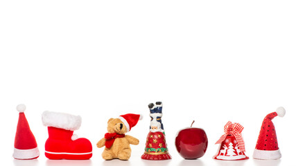 Weihnachtsdekoration, Weihnachtsmütze, Teddybär, Weihnachtsglocke, Apfel vor einem Weißen Hintergrund