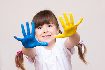 beautiful little girl with hands in the paint