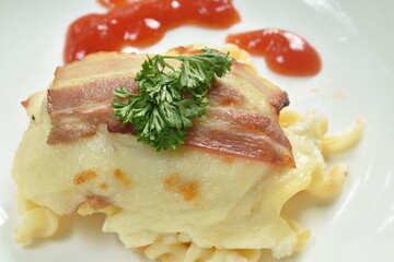 lasagna stuffed pasta topping grilled pork bacon dressing ketchup on plate