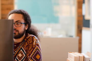 Portrait of young man sitting at computer in office