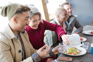 Smiling friends eating at restaurant outdoor patio