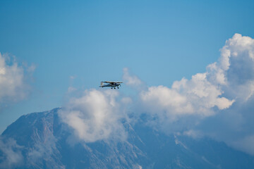 a piper in the air over the cloudy alps in austria
