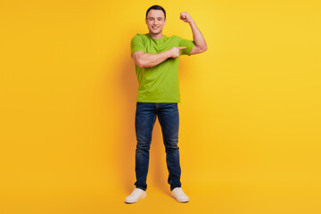 Fototapeta na wymiar Portrait of cheerful confident cool guy direct finger hands muscle on yellow background
