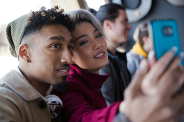 Smiling young couple taking selfie with camera phone