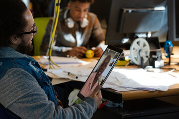 Man sitting at desk using tablet computer