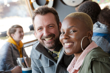 Obraz premium Portrait of smiling couple dining with friends at restaurant outdoor patio