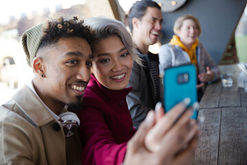Obraz premium Smiling young couple taking selfie with camera phone
