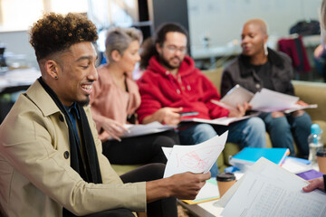 Colleagues discussing paperwork in office