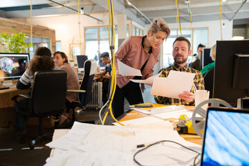 Man and woman discussing paperwork at desk