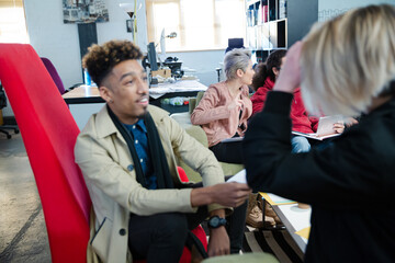 Colleagues discussing paperwork in office