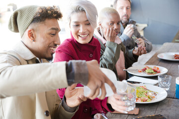 Smiling friends eating at restaurant outdoor patio