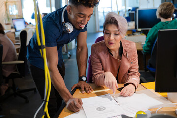 Man and woman discussing paperwork in office