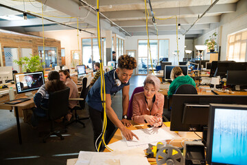 Man and woman discussing paperwork in office
