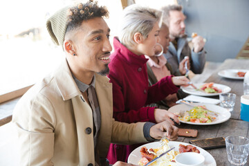 Smiling friends eating at restaurant outdoor patio