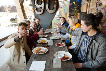 Portrait of smiling friends eating at restaurant outdoor patio