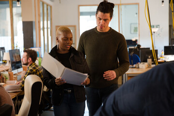 Man and woman discussing paperwork in office