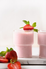 Strawberry lassi or milkshake on a white background. Close up. Healthy dairy Indian beverage.