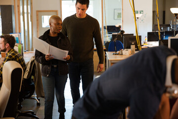 Man and woman discussing paperwork in office