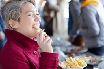 Smiling woman posing with food outdoors