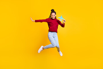 Fototapeta na wymiar Full length body size photo woman keeping paper craft plane jumping isolated vibrant blue color background
