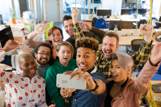 Team talking group selfie with smartphone in office