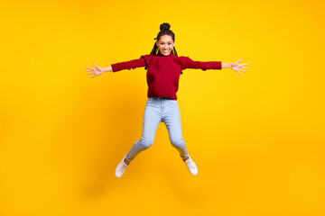 Fototapeta na wymiar Full length photo of sweet cute dark skin lady wear red pullover smiling jumping high isolated yellow color background