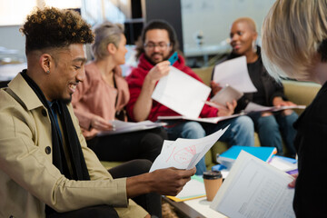 Colleagues discussing paperwork in office