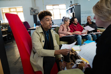 Man talking to friends in office, holding dog