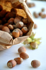 Hazelnut close-up. Hazelnuts in a paper bag on a wooden background. Hazelnut background, healthy food. Corylus. 