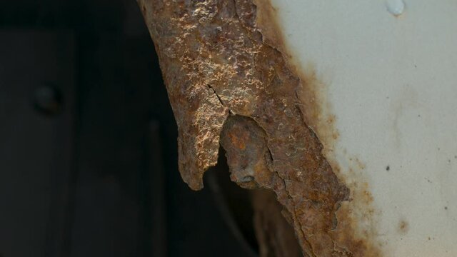 Deep rust on the body of a gray old car. Rust and corrosion hole on old worn out painted metal surface. Body parts repair. Need for repair.