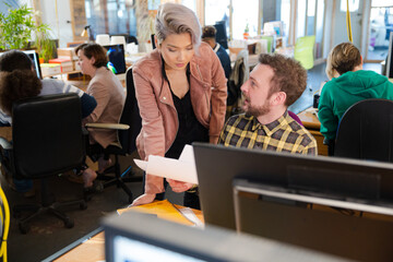 Man and woman discussing paperwork at desk