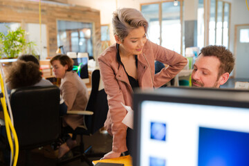 Man and woman discussing paperwork at desk