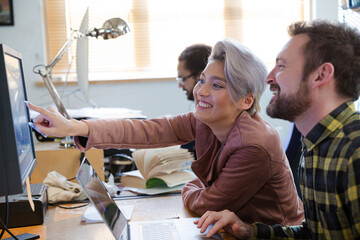 Colleagues working at computer in office