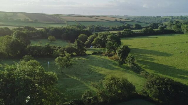 Ascending aerial shot over fields and farmland at dawn in the British countryside