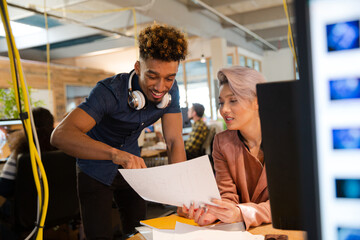 Man and woman discussing paperwork at desk