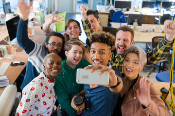 Team talking group selfie with smartphone in office