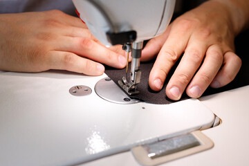 a man sewing on a sewing machine close-up