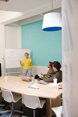 Businesswoman at whiteboard leading conference room meeting