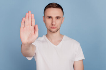 Photo of young handsome man unhappy sad show no stop sign decline refuse isolated over blue color...