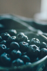 Fresh blueberries background with copy space for your text. Bright ripe berries in glass plate covered with water drops