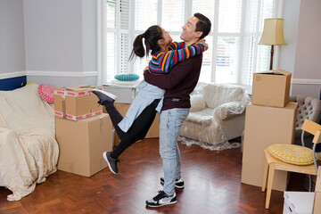 Happy, playful couple moving into new house