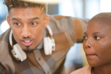 Man and woman discussing paperwork at computer