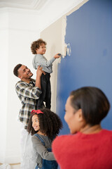 Happy family painting wall