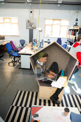 Young man working at laptop in modern armchair