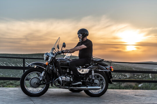 Mature man with sidecar in sunset with her bike