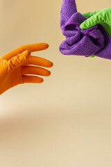 Hand in multi-colored rubber gloves holding a microfiber cloth for washing, cleaning concept