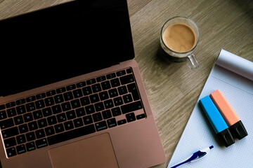 laptop, coffee, notebook, pen and highlighters