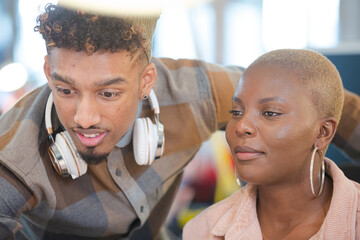 Man and woman discussing paperwork at computer