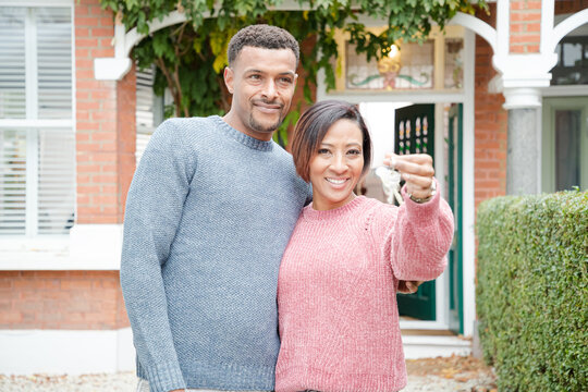 Portrait happy couple with keys to new house